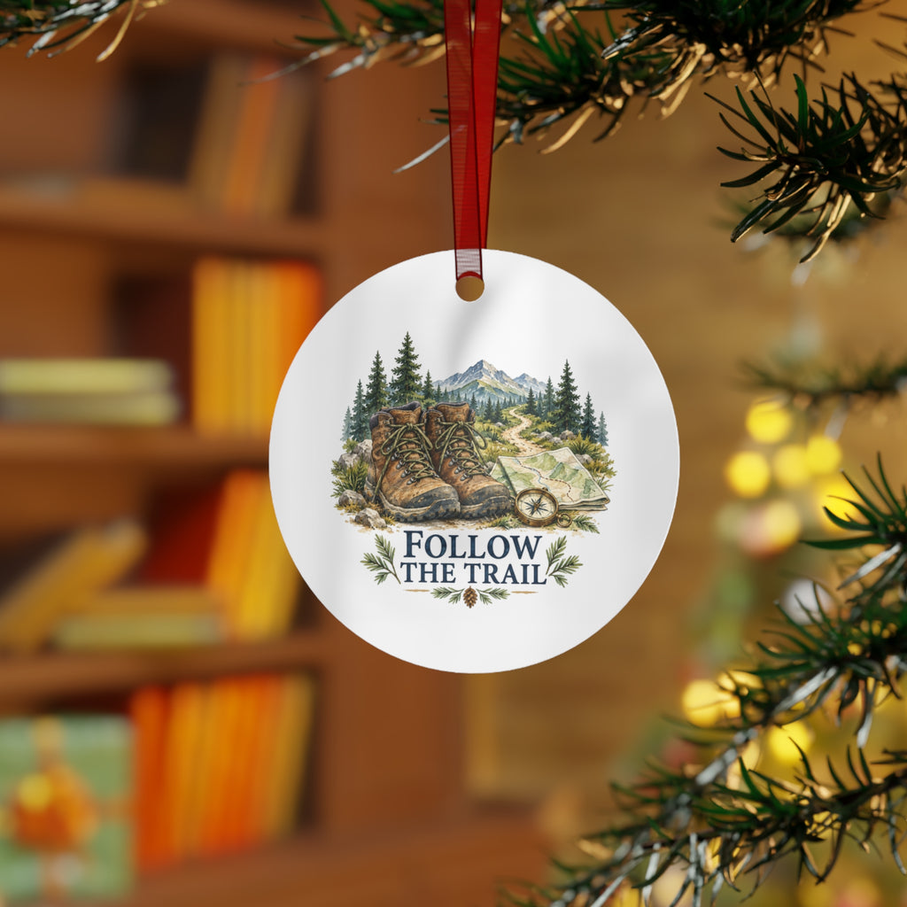 Lifestyle view of the round ornament with hiking artwork and red hanging ribbon.